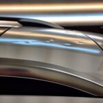 Shows the roof of a silver car, with hail dents.